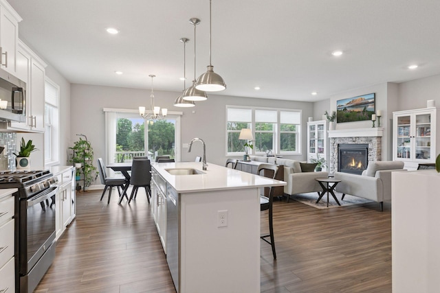3841 Hyde Ave N, Oakdale, MN 55128 - kitchen featuring stainless steel appliances, recessed lighting, a breakfast bar area, light countertops, and a stone fireplace