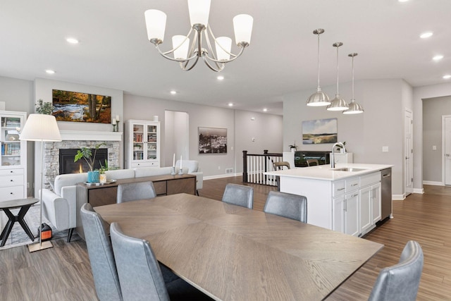 3841 Hyde Ave N, Oakdale, MN 55128 - dining room with a stone fireplace, wood finished floors, recessed lighting, and a chandelier