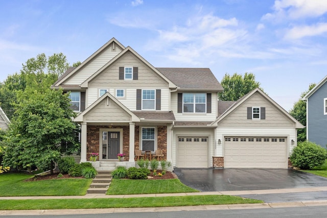 13332 Coachford Ave, Rosemount, MN 55068 - view of front of home with asphalt driveway, stone siding, a shingled roof, an attached garage, and covered porch