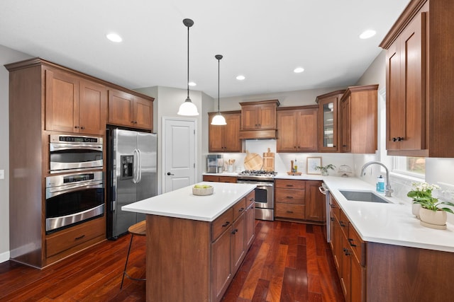 13332 Coachford Ave, Rosemount, MN 55068 - kitchen featuring appliances with stainless steel finishes, a center island, dark wood-type flooring, brown cabinetry, and recessed lighting