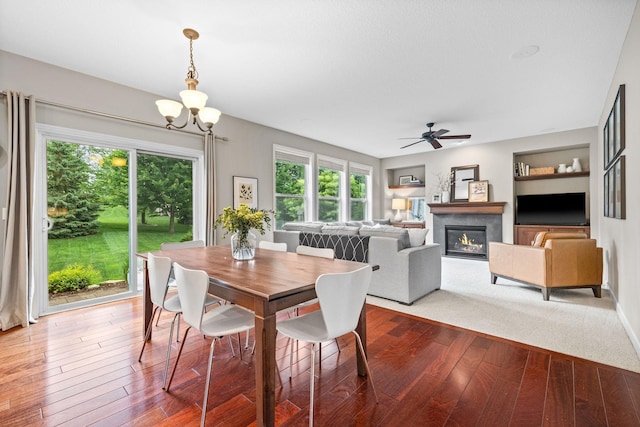 13332 Coachford Ave, Rosemount, MN 55068 - dining room with hardwood / wood-style floors, a chandelier, a glass covered fireplace, and a ceiling fan