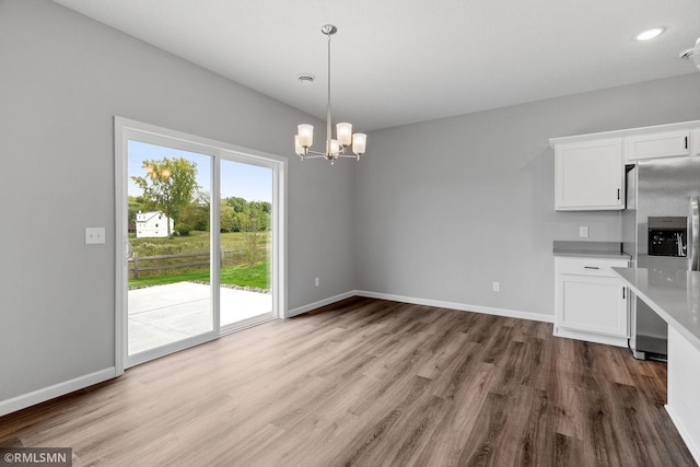 6817 104th St S, Cottage Grove, MN 55016 - kitchen with stainless steel fridge with ice dispenser, light countertops, wood finished floors, white cabinetry, and a chandelier