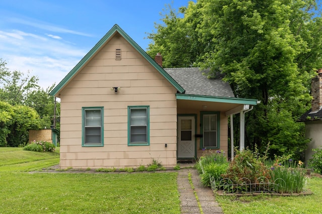 377 Winona St E, Saint Paul, MN 55107 - bungalow with a front yard, roof with shingles, a chimney, and covered porch