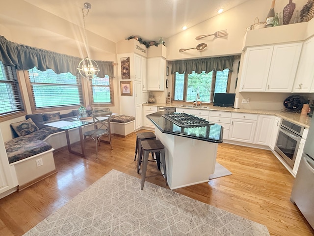 2228 Douglynn Ln, Saint Paul, MN 55119 - kitchen featuring stainless steel appliances, a chandelier, white cabinetry, light wood finished floors, and vaulted ceiling