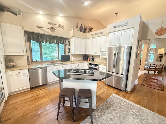 2228 Douglynn Ln, Saint Paul, MN 55119 - kitchen featuring stainless steel appliances, lofted ceiling, plenty of natural light, white cabinets, and light wood-style flooring