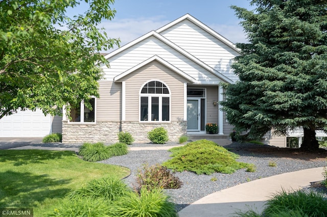 14578 Hunters Ln, Savage, MN 55378 - view of front of house with a garage, stone siding, a front yard, and asphalt driveway