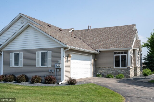 14578 Hunters Ln, Savage, MN 55378 - view of front of house featuring an attached garage, driveway, a shingled roof, a front lawn, and stone siding