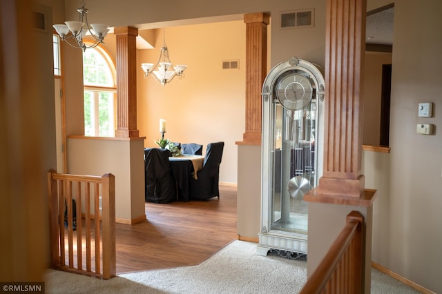 14578 Hunters Ln, Savage, MN 55378 - hallway with a chandelier, ornate columns, carpet flooring, and wood finished floors