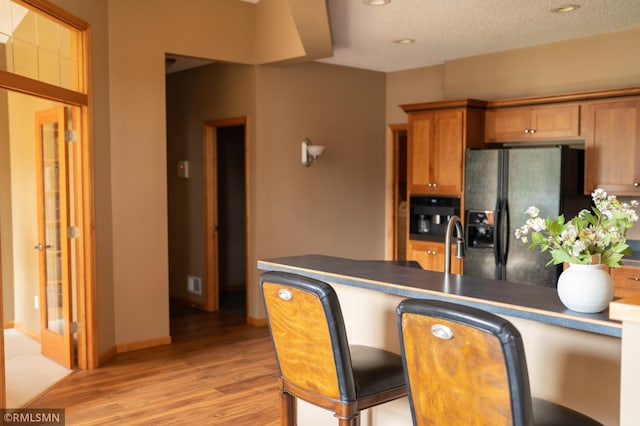 14578 Hunters Ln, Savage, MN 55378 - kitchen with fridge with ice dispenser, light wood-style floors, brown cabinets, recessed lighting, and a peninsula