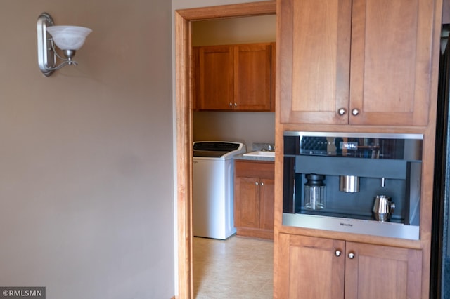 14578 Hunters Ln, Savage, MN 55378 - kitchen featuring washer / clothes dryer, light countertops, brown cabinets, and oven