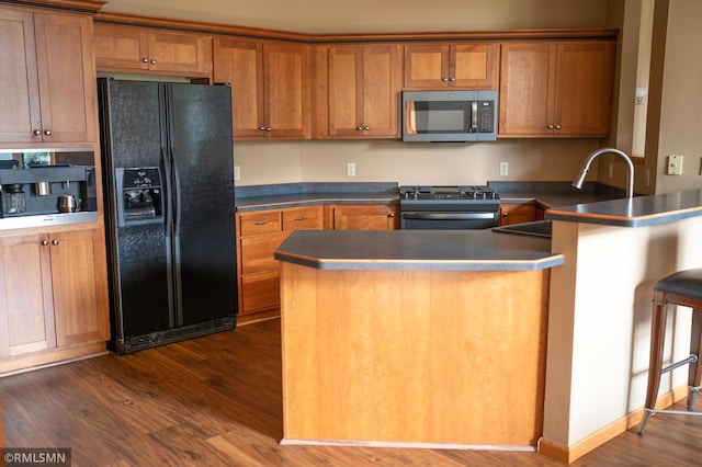 14578 Hunters Ln, Savage, MN 55378 - kitchen with stainless steel appliances, a peninsula, brown cabinets, and dark wood-style flooring