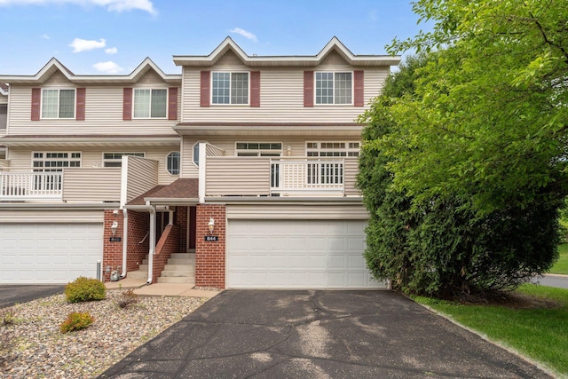 844 Coon Rapids Boulevard Extension NW, Coon Rapids, MN 55433 - view of front facade with asphalt driveway, a garage, a balcony, and brick siding