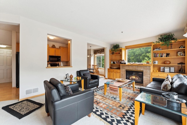 844 Coon Rapids Boulevard Extension NW, Coon Rapids, MN 55433 - living area featuring a tiled fireplace, light carpet, and a chandelier