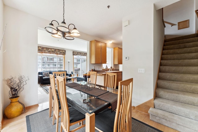844 Coon Rapids Boulevard Extension NW, Coon Rapids, MN 55433 - dining room with light wood-style floors, a chandelier, and stairs