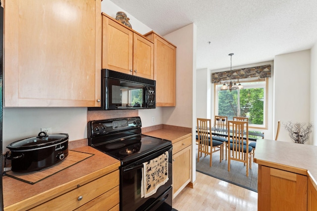 844 Coon Rapids Boulevard Extension NW, Coon Rapids, MN 55433 - kitchen featuring black appliances, light countertops, light wood-style floors, light brown cabinetry, and a textured ceiling