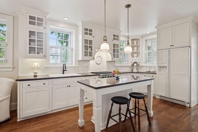 196 Mississippi River Blvd S, Saint Paul, MN 55105 - kitchen featuring paneled refrigerator, white cabinetry, a kitchen breakfast bar, dark wood finished floors, and hanging light fixtures