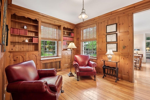 196 Mississippi River Blvd S, Saint Paul, MN 55105 - living area featuring radiator heating unit, built in features, wooden walls, wood-type flooring, and crown molding