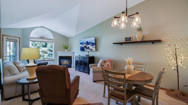 3504 Damon St Unit 38, Eau Claire, WI 54701 - dining area featuring vaulted ceiling, light carpet, a chandelier, and a glass covered fireplace