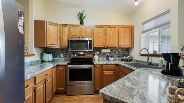 3504 Damon St Unit 38, Eau Claire, WI 54701 - kitchen featuring stainless steel appliances, lofted ceiling, decorative backsplash, light wood finished floors, and light countertops