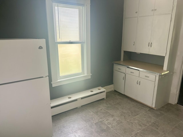 604 7th Ave E, Alexandria, MN 56308 - kitchen featuring freestanding refrigerator, a baseboard radiator, healthy amount of natural light, and white cabinetry