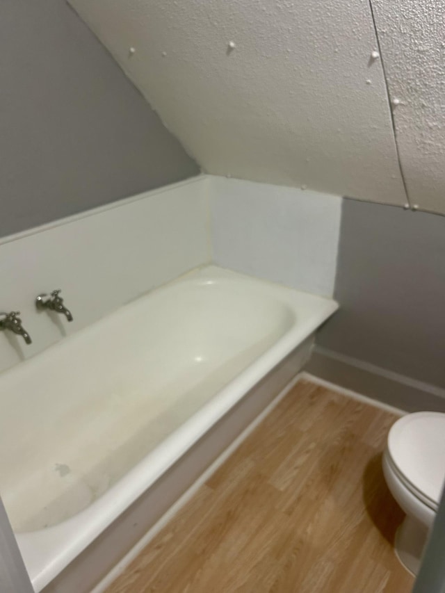 604 7th Ave E, Alexandria, MN 56308 - full bath featuring a tub to relax in, wood finished floors, a textured ceiling, and lofted ceiling