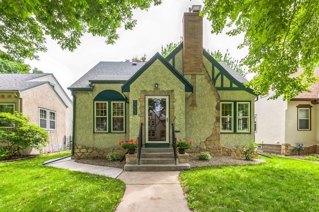 5223 15th Ave S, Minneapolis, MN 55417 - tudor house with a front yard, a chimney, roof with shingles, and stucco siding
