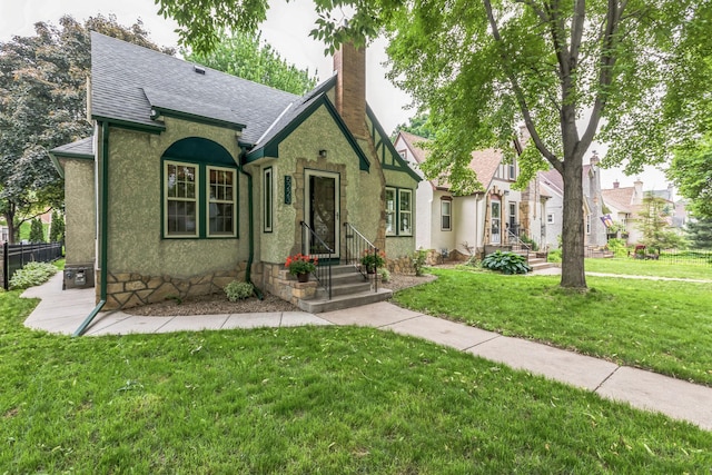 5223 15th Ave S, Minneapolis, MN 55417 - tudor-style house featuring roof with shingles, a chimney, and stucco siding