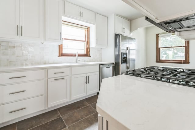 5223 15th Ave S, Minneapolis, MN 55417 - kitchen featuring stainless steel appliances, white cabinetry, backsplash, dark tile patterned flooring, and light stone counters