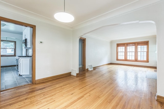 5223 15th Ave S, Minneapolis, MN 55417 - empty room featuring arched walkways, light wood finished floors, and crown molding