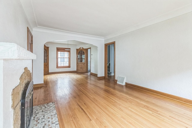 5223 15th Ave S, Minneapolis, MN 55417 - unfurnished living room with arched walkways, wood finished floors, a fireplace with flush hearth, and ornamental molding