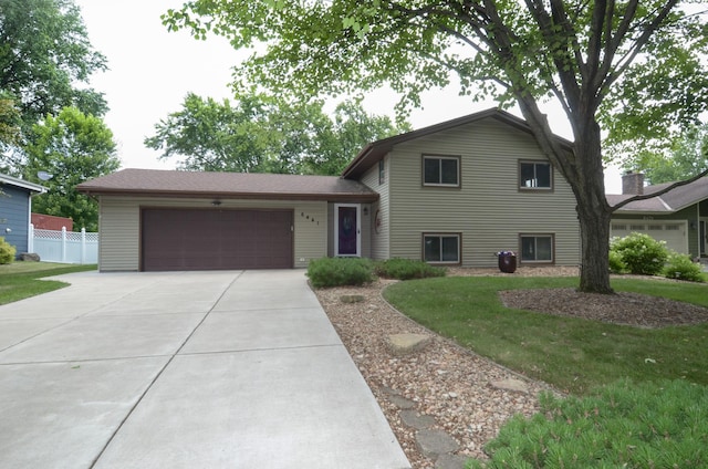 6441 Arthur St NE, Fridley, MN 55432 - split level home with concrete driveway and an attached garage