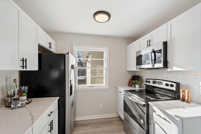 401 Plymouth Rd, Minnetonka, MN 55305 - kitchen featuring stainless steel appliances, backsplash, light wood finished floors, and light stone counters