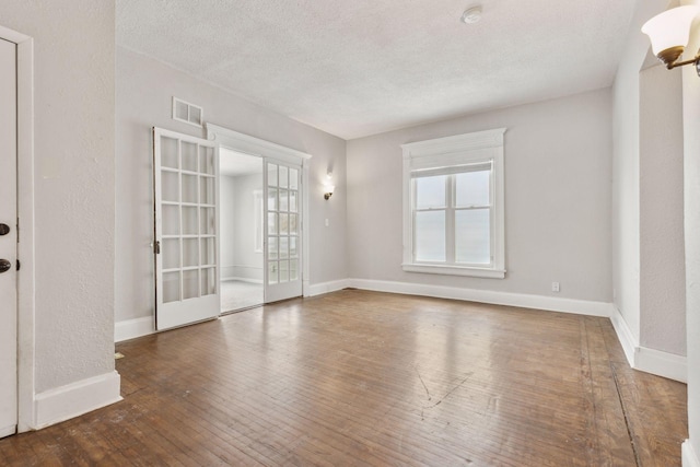 3208 Pleasant Ave, Minneapolis, MN 55408 - unfurnished room with healthy amount of natural light, a smoke detector, a textured ceiling, and hardwood / wood-style floors