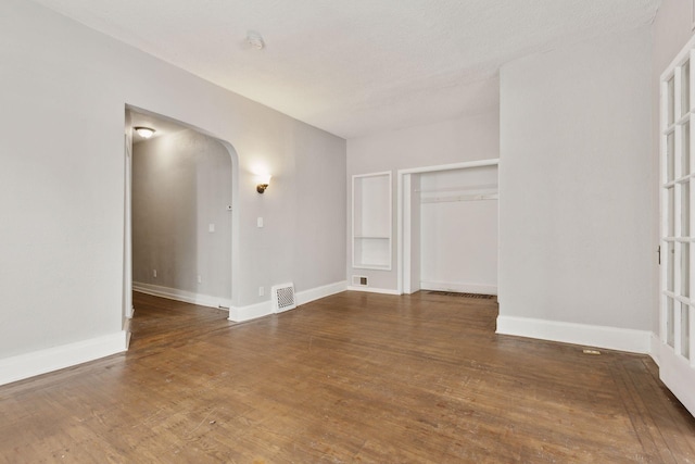 3208 Pleasant Ave, Minneapolis, MN 55408 - spare room featuring arched walkways and wood finished floors