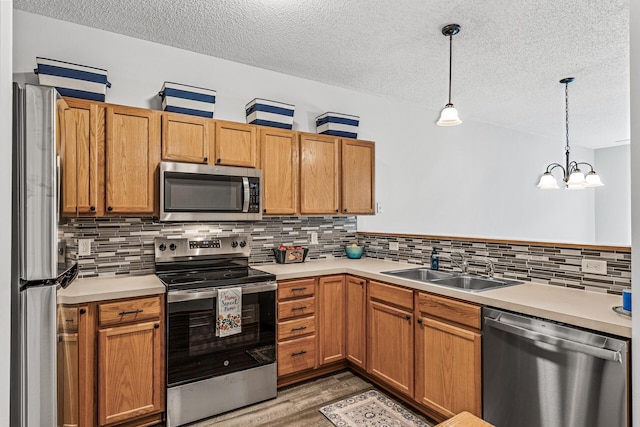 1587 Liberty St, Shakopee, MN 55379 - kitchen with appliances with stainless steel finishes, a textured ceiling, light countertops, and tasteful backsplash