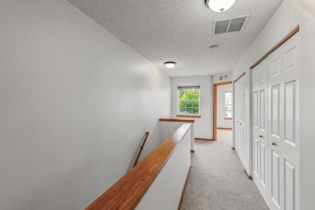 1587 Liberty St, Shakopee, MN 55379 - corridor featuring a textured ceiling, an upstairs landing, and light carpet