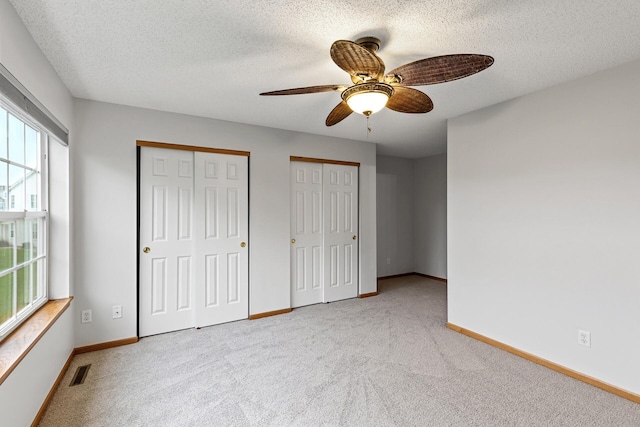 1587 Liberty St, Shakopee, MN 55379 - unfurnished bedroom with multiple windows, multiple closets, carpet floors, and a textured ceiling