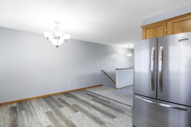 304 Tanager Path, Mankato, MN 56001 - kitchen featuring freestanding refrigerator, light wood-style floors, brown cabinets, a chandelier, and pendant lighting