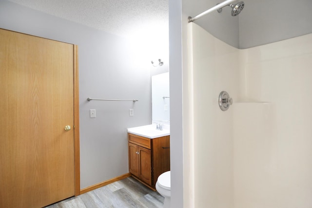 304 Tanager Path, Mankato, MN 56001 - bathroom featuring vanity, a shower, wood finished floors, and a textured ceiling