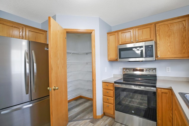 304 Tanager Path, Mankato, MN 56001 - kitchen featuring appliances with stainless steel finishes, light wood finished floors, light countertops, and brown cabinets