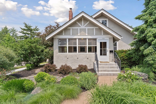 720 40th St, Minneapolis, MN 55409 - tudor house featuring stucco siding, a chimney, a sunroom, and entry steps