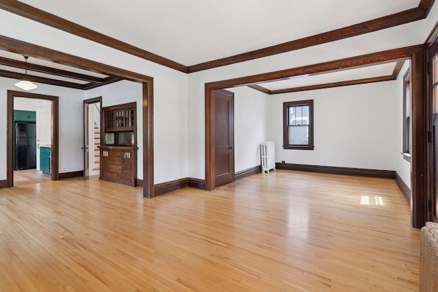 720 40th St, Minneapolis, MN 55409 - spare room featuring radiator heating unit, light wood-style flooring, beamed ceiling, and ornamental molding