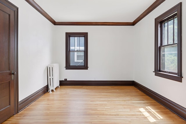 720 40th St, Minneapolis, MN 55409 - empty room with radiator heating unit, crown molding, and light wood-style flooring
