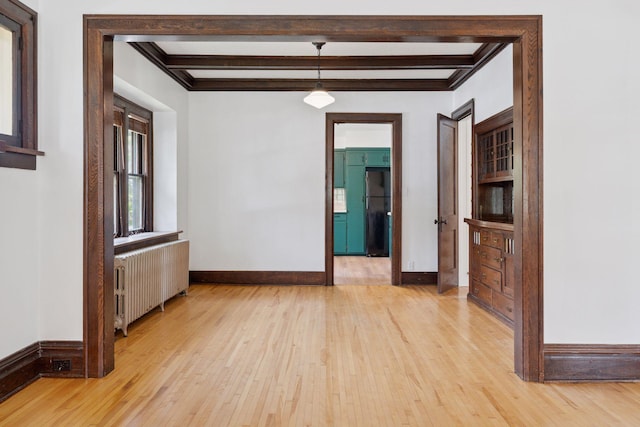 720 40th St, Minneapolis, MN 55409 - spare room featuring radiator heating unit, light wood-type flooring, and beamed ceiling