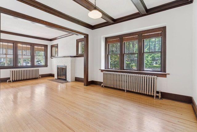 720 40th St, Minneapolis, MN 55409 - unfurnished living room with radiator, light wood finished floors, a fireplace, ornamental molding, and beam ceiling