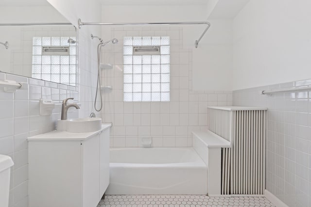 720 40th St, Minneapolis, MN 55409 - full bathroom with tile walls, vanity, tile patterned flooring, radiator, and washtub / shower combination