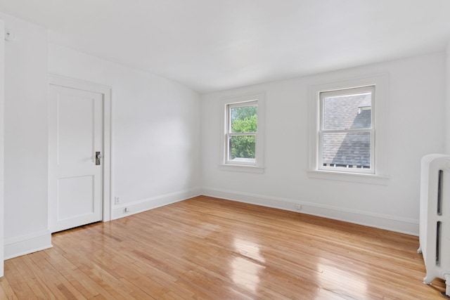 720 40th St, Minneapolis, MN 55409 - unfurnished room featuring radiator heating unit and light wood-style flooring