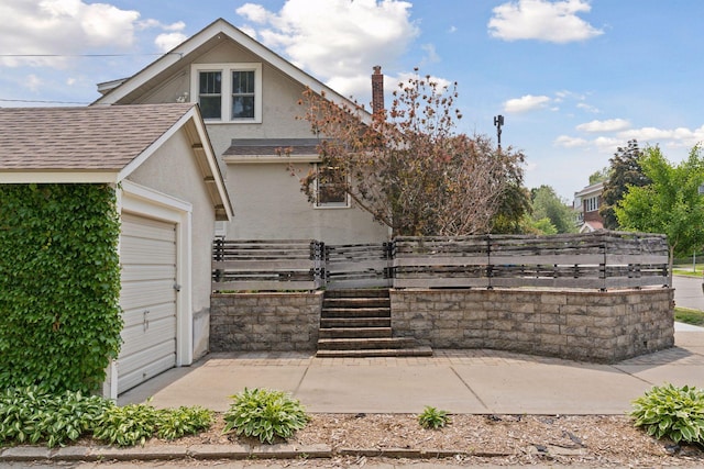 720 40th St, Minneapolis, MN 55409 - view of property exterior featuring stucco siding, a garage, a gate, and a shingled roof