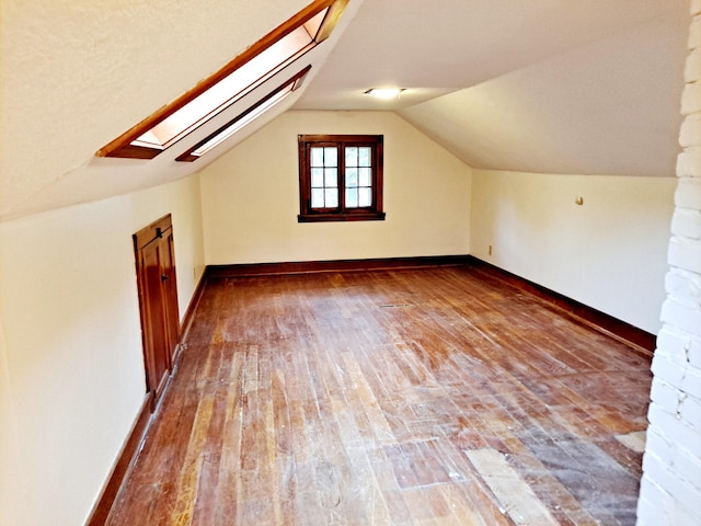 4223 12th Ave S, Minneapolis, MN 55407 - bonus room featuring hardwood / wood-style flooring, a skylight, and vaulted ceiling