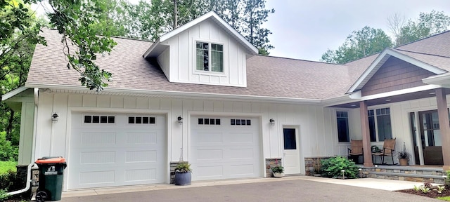 9029 Crown Hill Ct, Brainerd, MN 56401 - view of front facade with roof with shingles, board and batten siding, asphalt driveway, an attached garage, and stone siding